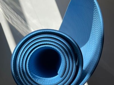 A yoga mat rolled out in a calm, minimalist room.
